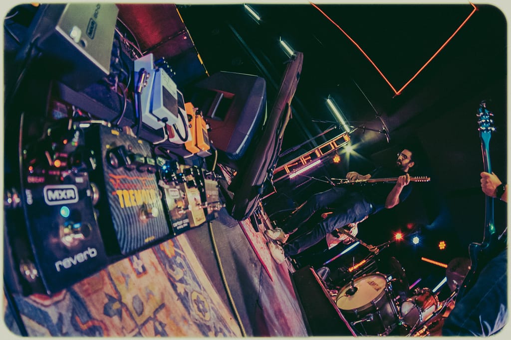 Pedalera de guitarra en concierto capturada por Yasunari Murayama, productor de fotografía y video en Mexicali. Fotografía de evento musical con luces escénicas y ambiente íntimo en foro dragon de Mision Dragon, Fotografía Profesional para Artistas en Vivo por el Productor de video y fotografo yasunari murayama de mexicali