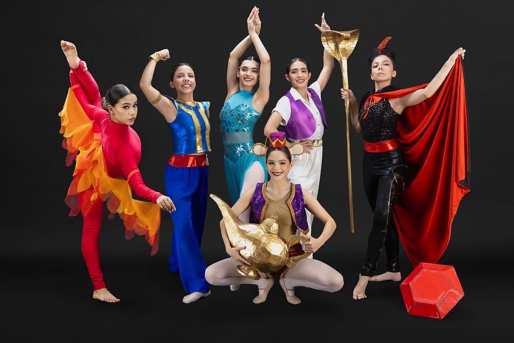 Group portrait of ProDanza Mexicali ballet instructors wearing red flame-winged costumes representing the scarlet bird from Disney’s Aladdin, photographed in a professional studio setting for the 2025 thematic dance show. Artistic direction and photography by Yasunari Murayama. Fotografía grupal profesional de maestras de Prodanza Mexicali con vestuarios inspirados en Aladdín, sesión de estudio montada en la escuela en Mexicali, Baja California, producción artística de alto nivel, fotografía para academias y escuelas de danza. fotografo y productor de video en mexicali yasunari murayama especialista en efectos especiales