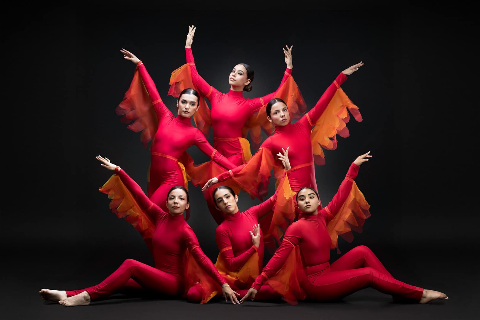 Group portrait of ProDanza Mexicali ballet instructors wearing red flame-winged costumes representing the scarlet bird from Disney’s Aladdin, photographed in a professional studio setting for the 2025 thematic dance show. Artistic direction and photography by Yasunari Murayama. FotografĂa artĂstica de grupo de bailarinas de Prodanza Mexicali en coreografĂa, vestuario rojo con detalles dorados inspirado en AladdĂn, sesiĂłn de estudio en Mexicali, Baja California, fotografĂa profesional para academias de danza y espectáculos artĂsticos.