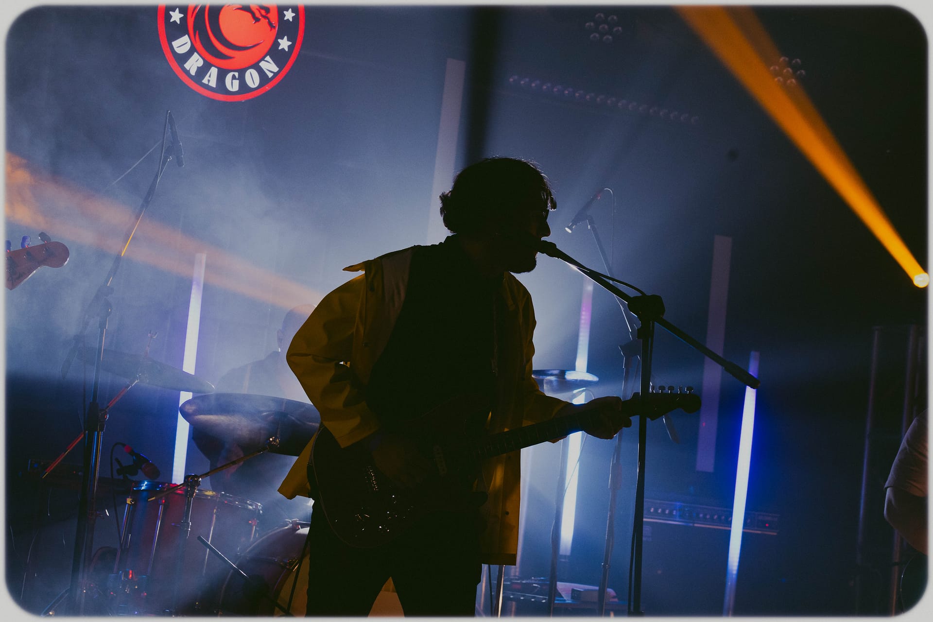 Vocalista con guitarra eléctrica cantando en silueta bajo luces dramáticas en Foro Dragón, capturado por Yasunari Murayama, productor de fotografía y video en Mexicali en foro dragon de Mision Dragon, Fotografía Profesional para Artistas en Vivo por el Productor de video y fotografo yasunari murayama de mexicali