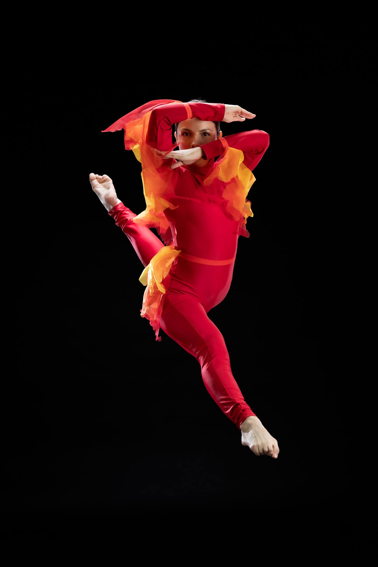 Fotografía profesional de bailarina de Prodanza Mexicali capturada en salto, vestuario rojo y dorado inspirado en Aladdín, fotografía de estudio con fondo negro, alta velocidad y calidad, Mexicali Baja California, producción artística para academias de danza. fotografo y productor de video en mexicali yasunari murayama especialista en efectos especiales